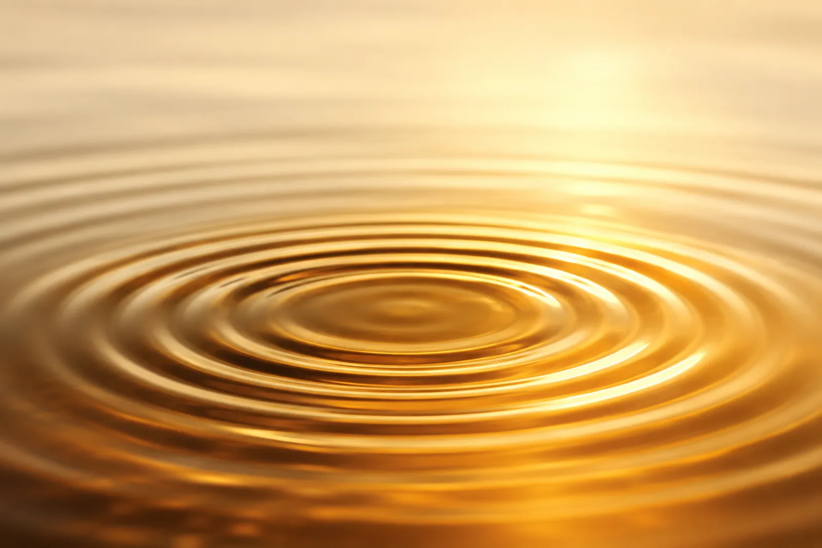 Konzentrische goldene Wellenringe auf ruhiger Wasseroberfläche – Sinnbild für innere Ausgeglichenheit und Klarheit